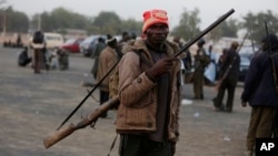 FILE - Boko Haram fighters have sized a multinational military base in the Nigerian town of Baga. In some areas where the Islamist extremists have been active, local hunters and vigilantes have taken up arms to defend themselves.