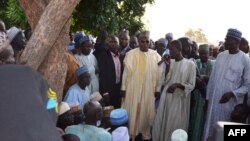 A villager speaks next to the governor of Borno State, Kashim Shettima (C) during Shettima's visit in Benisheik, after a gruesome attack by Boko Haram Islamists disguised in military uniforms in Nigeria, Sept. 19, 2013.