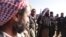FILE - Yazidi fighters gather on the summit of Mount Sinjar as they head to battle Islamic State militants, in Iraq, Dec. 21, 2014. IS swept into Sinjar town and surrounding villages in early August; many residents were from the Yazidi religious community.