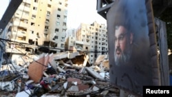 Foto dari mendiang pemimpin Hizbullah Hassan Nasrallah terlihat berada di lokasi yang menjadi target serangan Israel di pinggiran selatan Beirut, Lebanon, pada 7 November 2024. (Foto: Reuters/Mohammed Yassin)