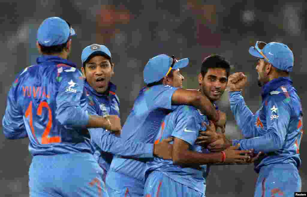 بھارتی کرکٹ ٹیم کے کھلاڑی پاکستانی بلے باز کامران اکمل کو آوٹ کرنے پر بھونیشور کمار کو شاباشی دیتے ہوئے