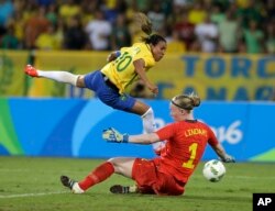 FILE - Brazil's Marta, left, leaps over Sweden goalkeeper Hedvig Lindahl as she attempts a shot on goal during a group E match of the women's Olympic football tournament between Sweden and Brazil at the Rio Olympic Stadium in Rio De Janeiro.