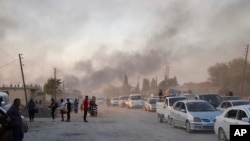 People flee shelling by Turkish forces in Ras al-Ayn, northeast Syria, Oct. 9, 2019.