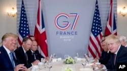 President Donald Trump and Britain's Prime Minister Boris Johnson, right, attend a working breakfast at the Hotel du Palais on the sidelines of the G-7 summit in Biarritz, France, Aug. 25, 2019. 