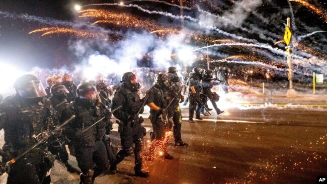 FILE - Police use chemical irritants and crowd control munitions to disperse protesters in Portland, Oregon, Sept. 5, 2020. Around the world, more than 119,000 people have been injured by tear gas and other chemical irritants since 2015, according to a report released Wednesday.