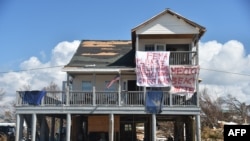 FILE - A sign that reads "FEMA please help make Mexico Beach great again" is seen on a damaged house by Hurricane Michael in Mexico Beach, Fla., on Oct. 15, 2018. 