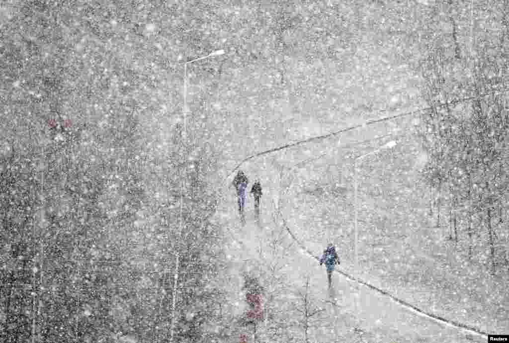 People walk during heavy snowfall in Minsk, Belarus.