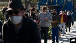 FILE - People wait in line for a COVID-19 test in Los Angeles, Jan. 4, 2022. 