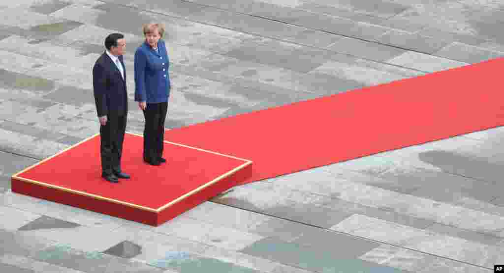 Chinese Premier, Li Keqiang , left, is welcomed by German Chancellor Angela Merkel with military honors at the Chancellery in Berlin, Germany. 