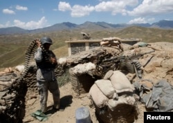 FILE - An Afghan border policeman prepares ammunition at a check post at the Goshta district of Nangarhar province, where Afghanistan shares borders with Pakistan, May 8, 2013.
