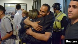 Eduardo Salazar (C), member of the Chacao district's police, greets a colleague as he arrives back at his workplace after being released from jail during a Christmas release from President Nicolas Maduro's government in Caracas, Venezuela, Dec. 23, 2017.