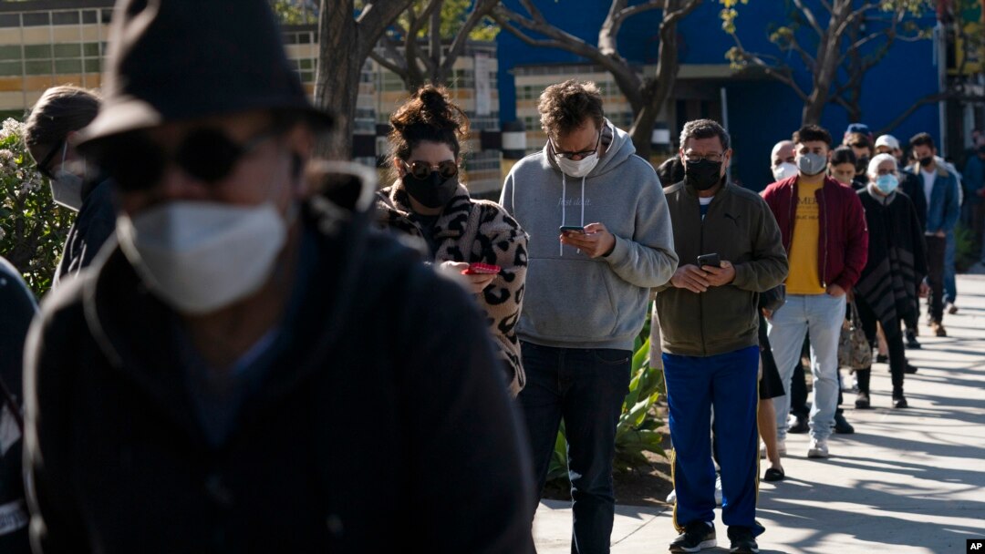 FILE - People wait in line for a COVID-19 test in Los Angeles, Jan. 4, 2022. 