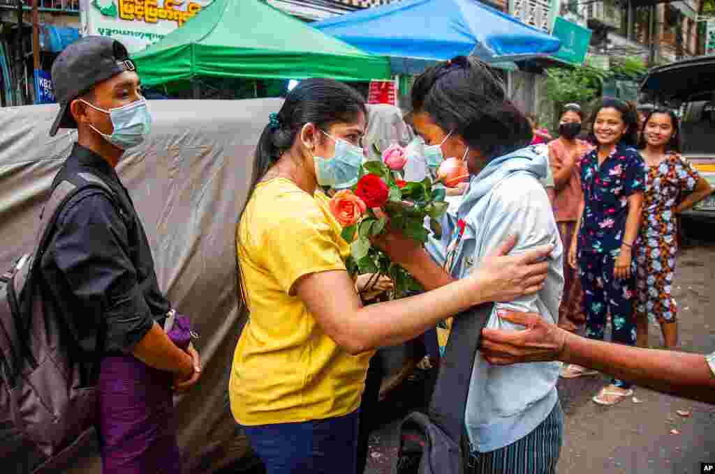 An anti-coup student protester is welcomed home with flowers by the residents of her neighborhood after being released from jail, in Yangon, Myanmar.