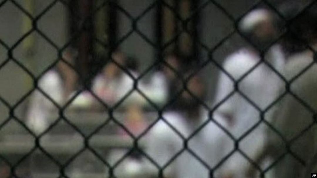 Inmates behind a fence at the military prison at Guantanamo Bay, Cuba