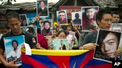 Exile Tibetans carry portraits of Tibetans who have immolated themselves in Tibet protesting Chinese rule, during a street protest in Dharmsala, India, Aug.29, 2012. 