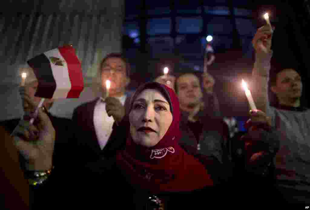 People take part during a candlelight vigil for victims of a Friday mosque attack at the Journalists Syndicate, in Cairo, Egypt.