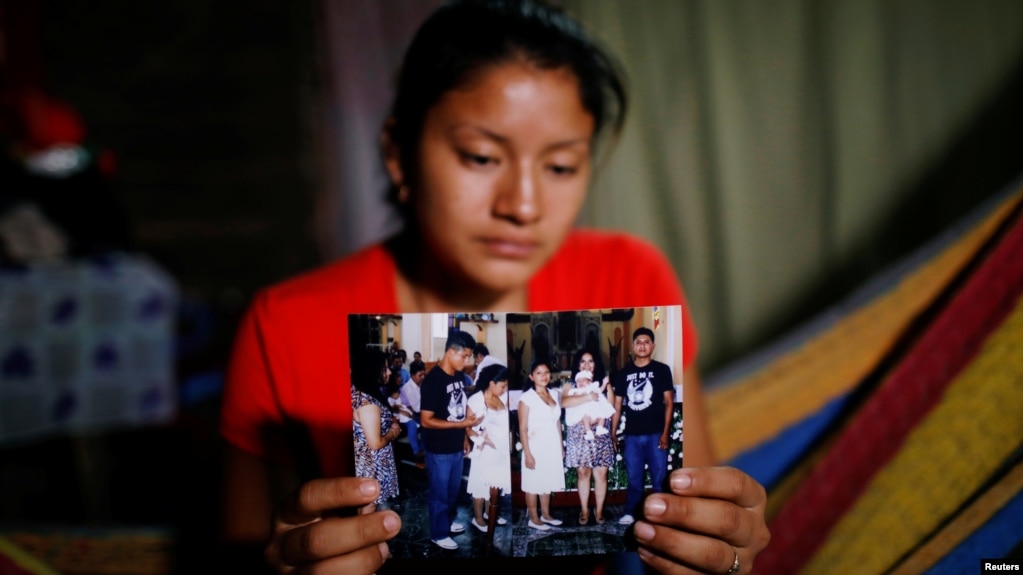 Norma Méndez, esposa del migrante salvadoreño Marvin González, quien murió en un centro de detención en Nuevo México, muestra fotos de Marvin en su casa de Verapaz, El Salvador, el 2 de agosto de 2019. REUTERS/José Cabezas.