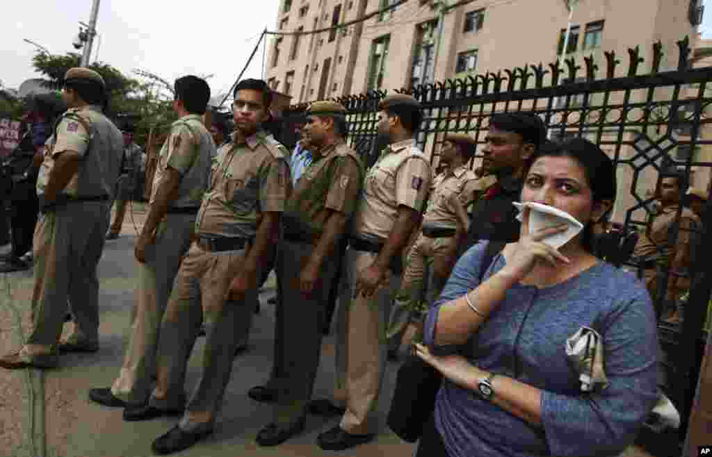 Delhi police secure a gate after protesters broke through a police barrier and entered the court complex demanding the death penalty for the four men convicted in the fatal gang rape of a young woman, New Delhi, Sept. 11, 2013. 