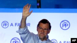 Spain's acting Primer Minister and candidate of Popular Party Mariano Rajoy, waves to his supporters as he celebrates the results of the party during the national elections in Madrid, Spain, Sunday, June 26, 2016.