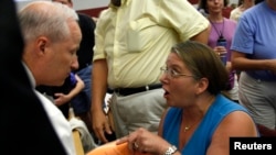 FILE - Diane Turek yells at Rep. Mike Coffman, R-Colo., at a town hall meeting on health care reform hosted by Coffman in Littleton, Colorado, Aug. 12, 2009. 
