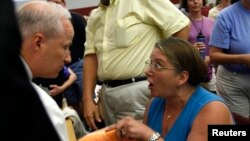 FILE - Diane Turek yells at Rep. Mike Coffman, R-Colo., at a town hall meeting on health care reform hosted by Coffman in Littleton, Colorado, Aug. 12, 2009. 