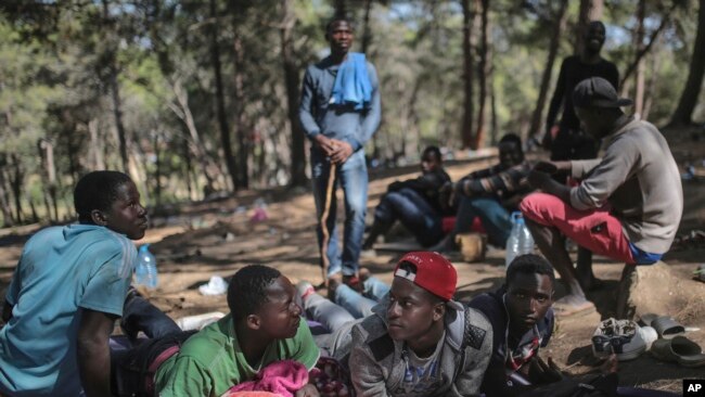 FILE - Sub-Saharan migrants aiming to cross to Europe take shelter in a forest overlooking the neighborhood of Masnana, on the outskirts of Tangier, Morocco, Sept. 5, 2018.