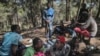 FILE - Sub-Saharan migrants aiming to cross to Europe take shelter in a forest overlooking the neighborhood of Masnana, on the outskirts of Tangier, Morocco, Sept. 5, 2018.