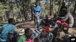 FILE - Sub-Saharan migrants aiming to cross to Europe take shelter in a forest overlooking the neighborhood of Masnana, on the outskirts of Tangier, Morocco, Sept. 5, 2018.