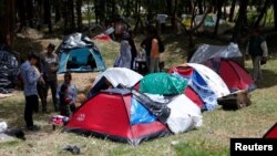 Venezuelan migrants stand at a makeshift camp near the transport terminal in Bogota, Colombia, Sept. 5, 2018. 