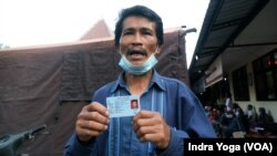 Seniman, salah satu pengungsi erupsi Gunung Semeru, sedang menunjukkan KTP anaknya, Muhammad Hermansyah, yang masih belum ditemukan pasca guguran awan panas Gunung Semeru pada 4 Desember 2021. Foto diambil pada 7 Desember 2021. (Foto: VOA/Indra Yoga)