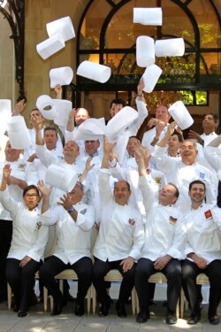 Anggota Club des Chefs des Chefs (Club of Leaders' Chefs) melemparkan topi koki mereka saat berpose di depan Plaza Athenee Hotel sebelum dimulainya pertemuan di Paris, Perancis, 23 Juli 2012. (REUTERS/Charles Platiau)