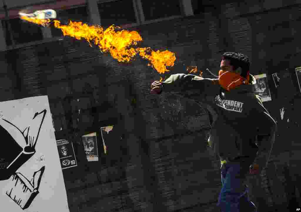 A protester throws a molotov cocktail at Bolivarian National Police during a protest against the government of President Nicolas Maduro in Caracas, Venezuela, June 24, 2014. 