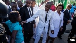 Haitian President Jovenel Moise, center, accompanied by Haitian first lady Martine Moise, speaks with a protesters at a demonstration in Port-au-Prince, Oct. 17, 2018.