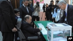 Presiden Abdelaziz Bouteflika, duduk di kursi roda memberikan suaranya dalam Pemilu Aljazair (17/4/2014).