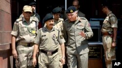 Indian Border Security Force (BSF) Director General D.K. Pathak, center left, and Pakistani Rangers Director General (Punjab) Maj. Gen Umar Farooq Burki, center right, chat as they leave after their meeting with Indian Home Minister Rajnath Singh in New D