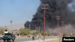 Asap hitam mengepul dari markas besar kepolisian di Gardez, ibukota provinsi Paktia, Afghanistan, sementara pasukan keamanan Afghanistan berjaga-jaga setelah seorang pembom mobil bunuh diri dan orang-orang bersenjata menyerang markas tersebut, 17 Oktober 2017.