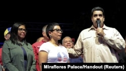 Prezidan venezuelyen an, Nicolàs Maduro (adwat) ki tap pale nan yon rankont ak kèk patizan pandan li te gen avèk li Prezidant Asanble Nasyonal Konstitiyant la, Delcy Rodriguez (an vèt oliv, agoch).