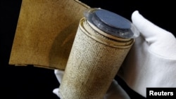 Seorang karyawan memperlihatkan gulungan manuskrip Marquis de Sade Le Rouleau de la Bastille, "Les 120 jours de Sodome ou l'ecole du libertinage" (The 120 Days of Sodom, or the School of Libertinage, 1785), sebelum pelelangan di rumah lelang Hotel Drouot, di Paris, Perancis, 23 November 2017. 