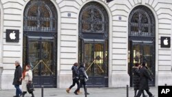 FILE - In this Jan. 1, 2013 file photo, Parisians and tourists wander in front of an Apple store in Paris. A French prosecutor office said Jan. 9, 2018 an investigation into Apple over alleged planned obsolescence of some of its smartphones has been opened.