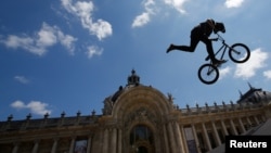 A BMX rider performs in the air in front of the Petit Palais in Paris, France, June 23, 2017, as Paris transforms into a giant Olympic park to celebrate International Olympic Days. 