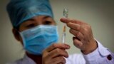 FILE - In this Monday, Nov. 16, 2009 file photo, a health worker prepares a dose of H1N1 vaccine at the start of a free vaccination program intended for all Beijing residents at a clinic in Beijing. 