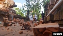 Balinese Hindu men look at a Hindu temple damaged following an earthquake in Denpasar, Bali, Indonesia, July 16, 2019, in this photo taken by Antara Foto.