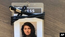 A press badge for Des Moines Register reporter Andrea Sahouri features her jail booking photo from her May 31, 2020 arrest while covering a Black Lives Matter protest.