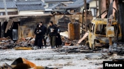 Seniman pernis Jepang Kohei Kirimoto mencari kucingnya yang hilang bersama anggota keluarganya, dekat pasar pagi "Asaichi" yang terbakar akibat kebakaran, di Wajima, Jepang, 4 Januari 2024. (Foto: REUTERS/Kim Kyung- Hoon)