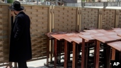 An ultra-Orthodox Jewish man speaks to a woman across a fence separating men and women at the Western Wall, the holiest site where Jews can pray in Jerusalem's old city, April 10, 2013.