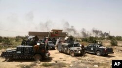 Smoke rises from Islamic State positions as Iraqi federal police take combat positions at the front line during fight against IS outside Fallujah, May 28, 2016. 