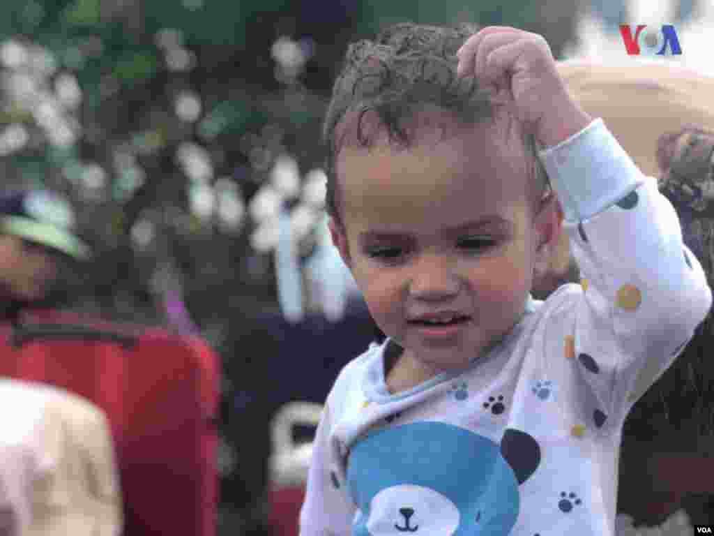 Niño juega mientras espera con su familia para cruzar a Brasil por&nbsp;Pacaraima. Foto: Celia Mendoza - VOA.