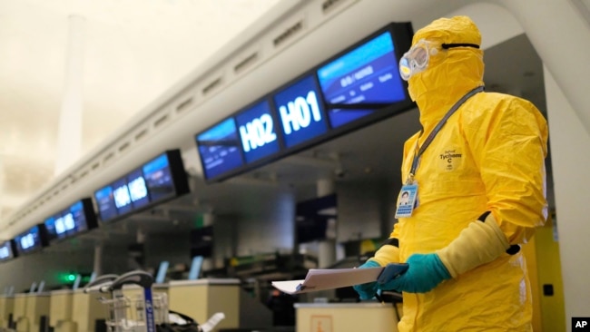 2020年2月1日武汉天河国际机场一名工作人员身穿防护服手持文件。随后一架搭载欧盟国家公民的班机飞离天河国际机场。资料照。