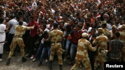 FILE -- Demonstrators chant slogans and flash the Oromo protest gesture during Irreecha, the thanksgiving festival of the Oromo people, in Bishoftu town, Oromia region, Ethiopia. 