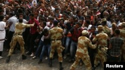 FILE - Security forces work to contain demonstrators at an anti-government rally in Bishoftu town, Oromia region, Ethiopia, Oct. 2, 2016. Initially triggered by land issues, the protests have shifted to include human rights and political power.